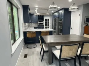 Navy blue kitchen renovation with modern cabinetry and dining area
