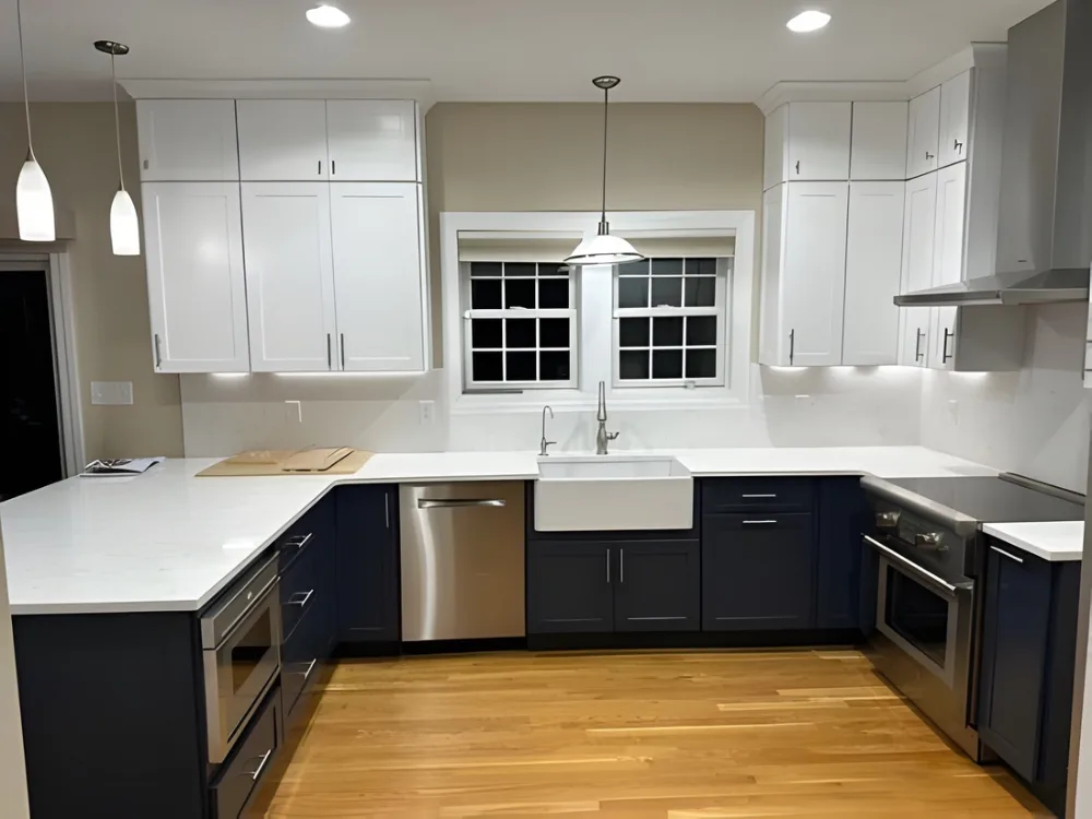 modern kitchen renovation with white and navy cabinets and farmhouse sink