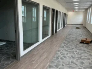Commercial interior painting, flooring, and door installation in office hallway.