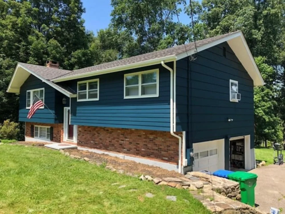 Exterior painting restoration with painters working on ladders